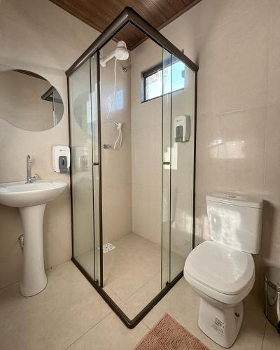 a bathroom with a shower and a toilet and a sink at Suítes no centro de Bonito, Bonito Brasil Turismo in Bonito