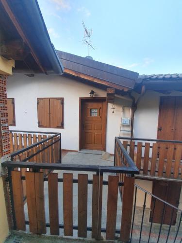 a house with a wooden door on a balcony at Maison du coeur - Bien-être in Challand Saint Anselme