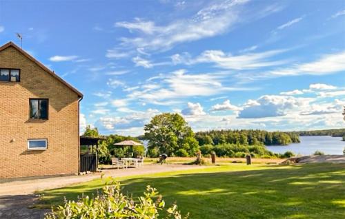 a house with a grassy yard next to a lake at Nice Home In Rörvik With Wifi in Rörvik