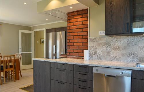 a kitchen with a counter and a brick wall at Beautiful Home In Strängnäs With Sauna in Strängnäs