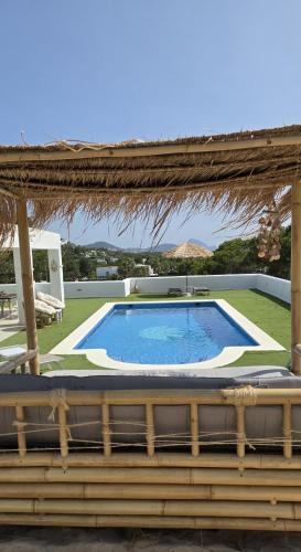 a large swimming pool in a yard with a pergola at Villa Can Kiko Ibiza in San Jose