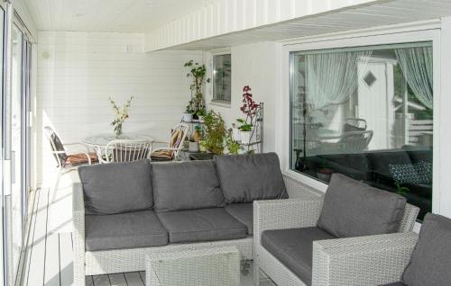 een woonkamer met een bank en een tafel op een veranda bij 2 Bedroom Cozy Home In Skärholmen in Stockholm