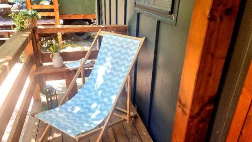 a blue rocking chair sitting on a porch at Bendji Land - vacation hideaway, close to Sofia in Ribarica