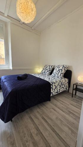 une chambre avec un lit avec une couette bleue dans l'établissement Entre vignes et Canal du Midi Appart 6 pers rénové, à Ginestas