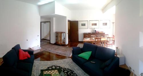 a living room with two blue couches and a kitchen at Pit stop in Villa nel Verde a Roma-Aeroporto di Ciampino in Rome