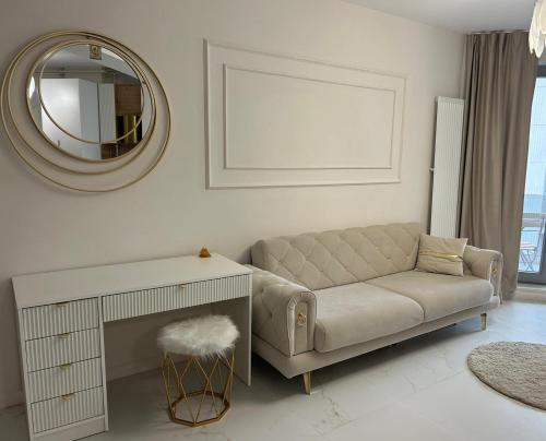 un soggiorno con un divano e uno specchio di Studio KMS Mamaia Nord a Mamaia Nord - Năvodari