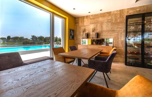 a dining room with a table and a swimming pool at Stunning Apartment In Rogasovci in Rogašovci