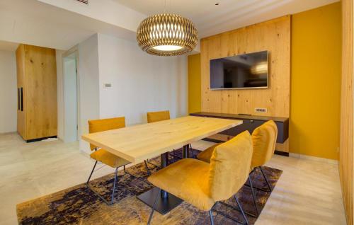 a dining room with a wooden table and yellow chairs at Stunning Apartment In Rogasovci in Rogašovci