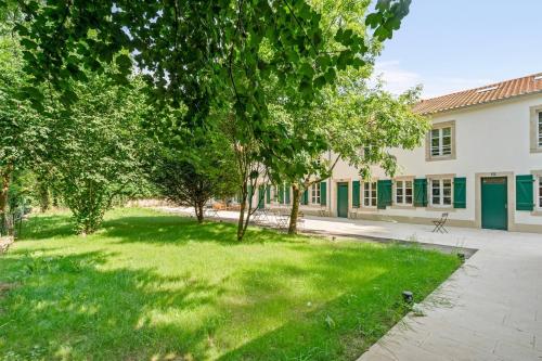 a park in front of a building with trees at Gîte Lasauvage 83 in Differdange