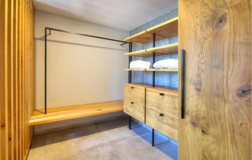 a walk in closet with wooden cabinets and blue shelves at Amazing Apartment In Rogasovci in Rogašovci