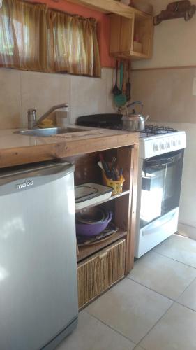 een keuken met een aanrecht met een fornuis en een wastafel bij Casa de Olga in Tandil