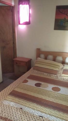 twee bedden in een kleine kamer met een raam en een raam bij Casa de Olga in Tandil