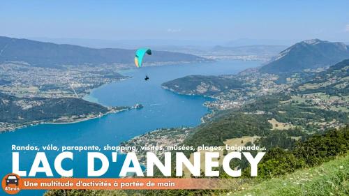a person flying a kite over a body of water at CHALET 1703 - Refuge Alpin avec Spa & Sauna - l'esprit maison au Coeur des Alpes - Adults Only in Le Petit-Bornand-lès-Glières