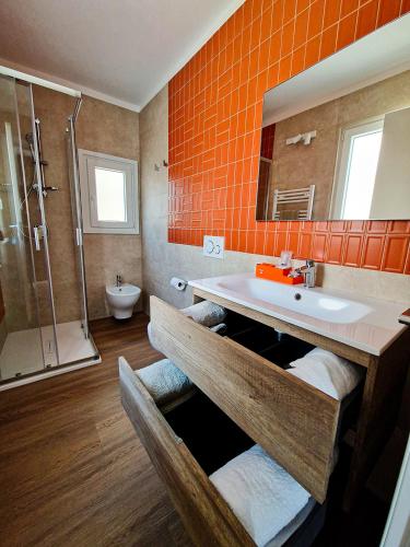 an orange bathroom with a sink and a shower at Dimora Odigitria in Bitritto