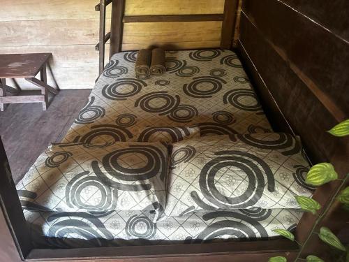 a bed with a design on the floor in a box at Cabaña los Termales in Nuquí