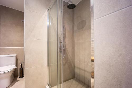 a shower stall in a bathroom with a toilet at Aethon Airport Project-FREE SHUTTLE by GK Properties in Markopoulo