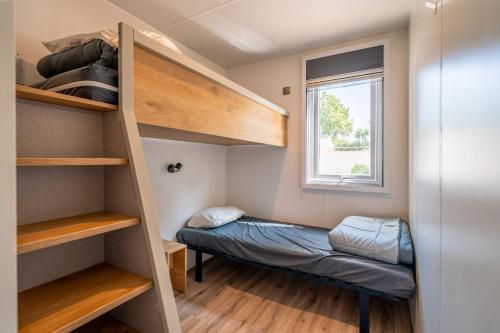 a small room with bunk beds and a window at Cocon Marin dans Camping 5 étoiles in Vendres-Plage