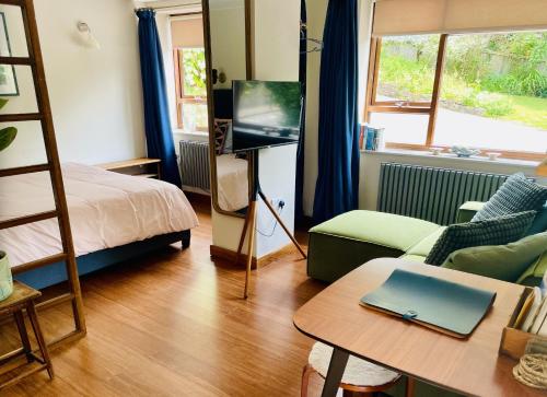 a living room with a bed a couch and a tv at The Hideaway Apartment, Bath in Bath