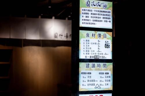 a sign with asian writing on it next to a wall at Garden Spring Hotel in Jiaoxi