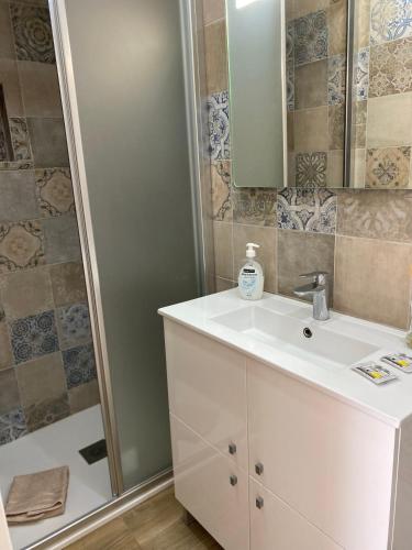 a bathroom with a white sink and a shower at Castle House in Palmela