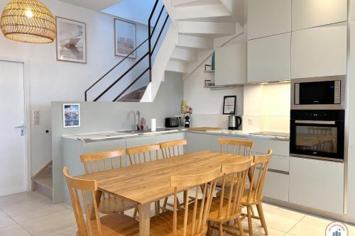 une cuisine avec une table et des chaises en bois dans l'établissement Les Roches Noires - Terrasse Vue Mer, à Trouville-sur-Mer