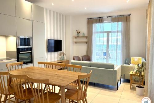 un salon avec une table et un canapé dans l'établissement Les Roches Noires - Terrasse Vue Mer, à Trouville-sur-Mer