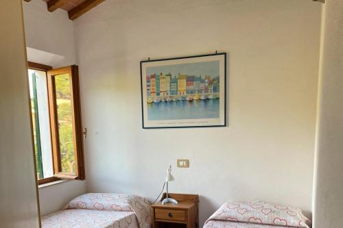 a bedroom with two beds and a picture on the wall at Appartamenti Casa Gemma - Goelba in Procchio