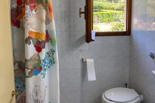 a bathroom with a shower curtain and a toilet at Appartamenti Casa Gemma - Goelba in Procchio