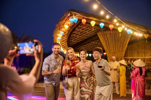 a group of people posing for a picture on a stage at ROBINSON Nam Hoi An in Tam Ky