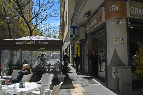 a street with tables and chairs outside a city cafe at Incoming Municipio in Naples