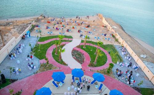 an overhead view of a park with people and blue umbrellas at كذابلانكا بيتش in Hurghada