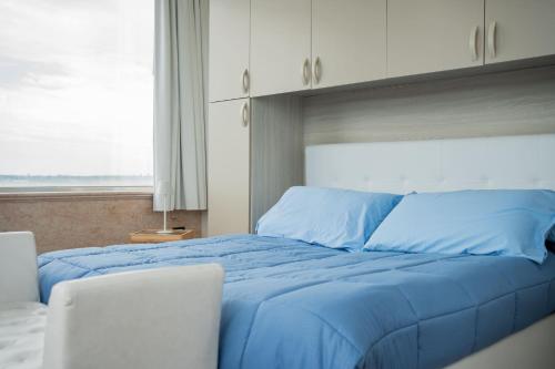 a blue bed in a bedroom with a window at The Lodge Salento - San Foca in San Foca