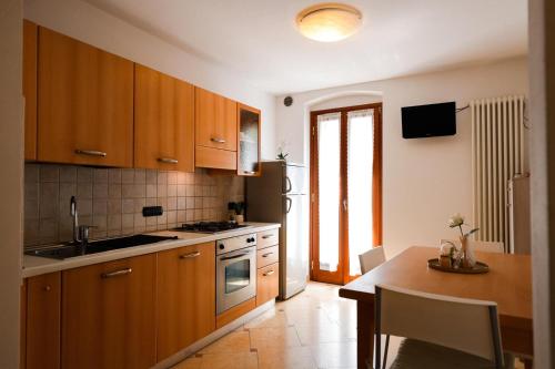 a kitchen with wooden cabinets and a wooden table with a tableablish at Il Cuore del Lago in Lazise