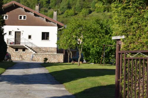 a fence in front of a house with a yard at Appartement Le 510 in Aigueblanche
