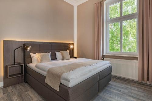 ein Schlafzimmer mit einem großen Bett und zwei Fenstern in der Unterkunft Villa Carmen Strandkorb in Ahlbeck