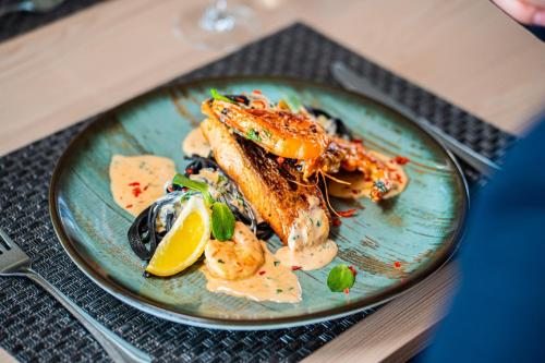 a plate of food with seafood on a table at Sungarden Wellness Hotel Siófok in Siófok