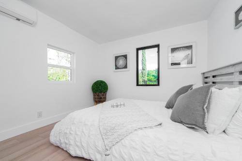 a white bedroom with a bed and two windows at #Marbella Lane - Classy 3BR Jewel with Open Vibe in Yorba Linda