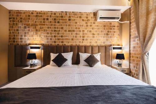 a bedroom with a large bed with a brick wall at Art Air Hotel in Tashkent
