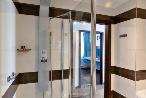 a bathroom with a shower with a glass door at Hotel Milenium in Legnica