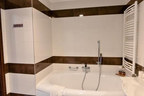 a bathroom with a tub and a sink at Hotel Milenium in Legnica