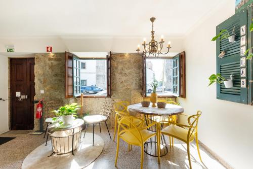 a dining room with yellow chairs and a table at Villa 5 in Vila do Conde