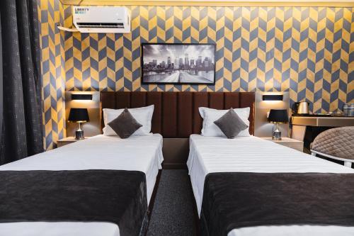a hotel room with two beds and a desk at Art Air Hotel in Tashkent