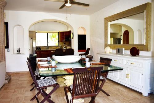 a dining room with a table and a mirror at Vidanta Villas Golf - Jacuzzi, Alberca, Lago in Acapulco