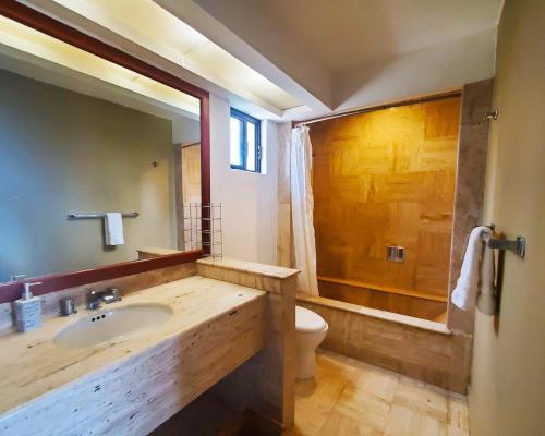 a bathroom with a sink and a toilet and a tub at Vidanta Villas Golf - Jacuzzi, Alberca, Lago in Acapulco