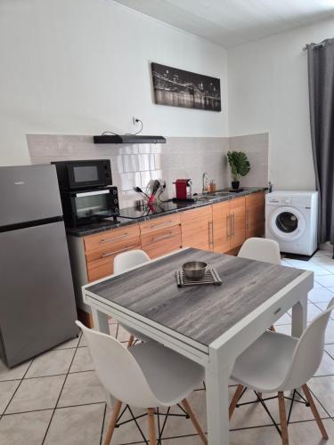 une cuisine avec une table et des chaises dans une cuisine dans l'établissement Chez Pat, Appartement centre ville de Vias(34), mer à 2,5km, à Vias