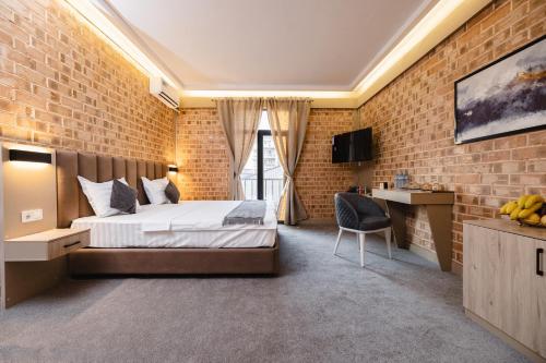a bedroom with a bed and a brick wall at Art Air Hotel in Tashkent