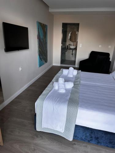 a bedroom with a large white bed with towels on it at Panorama Hideaway in Dassia