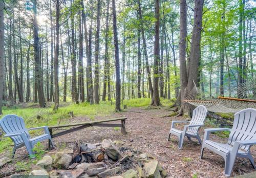 three chairs and a fire pit in the woods at The Babbling Brooke in Blakeslee