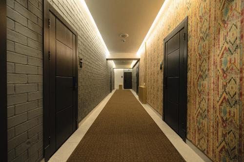 a hallway with two black doors and a carpeted aisle at Art Air Hotel in Tashkent