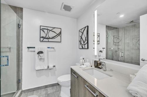 a white bathroom with a sink and a toilet at Sunset Waterview Oasis Studio in Miami